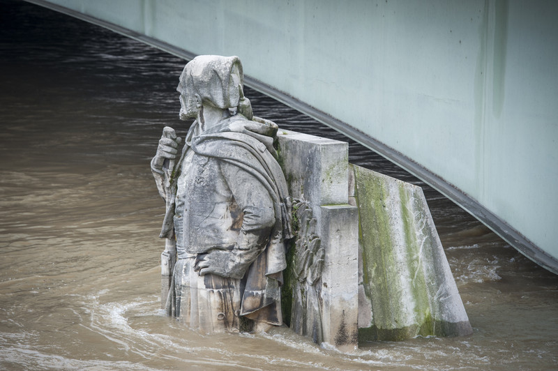 epa05344341 People watch the flood water levels of Seine river from Pont de l'Alma bridge with the partially submerged statue 'Le Zouave' in Paris, France, 03 June 2016. Floods and heavy rain drenched about a quarter of the French territory over several days. EPA/JEREMY LEMPIN