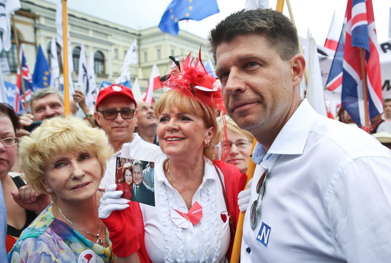 epa05345857 Party leader Nowoczesna Ryszard Petru (R) takes part in the march organised by Polish Committee for the Defence of Democracy (KOD) in Warsaw, Poland, 04 June 2016. The march under the slogan 'All for Freedom' to commemorate the anniversary of the first post-war Polish, partially free elections of 04 June 1989. EPA/RAFAL GUZ POLAND OUT