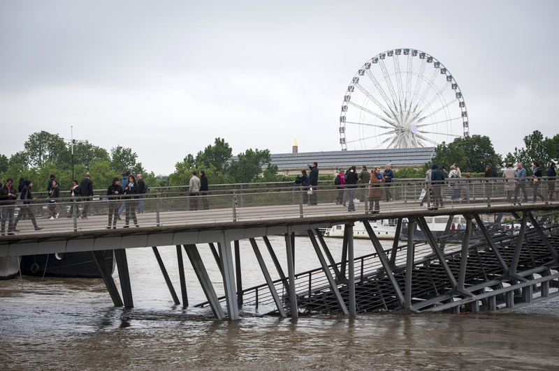 epa05344091 The Solferino bridge is partially submerged by the flooding of the Seine river in Paris, France, 03 June 2016. Floods and heavy rain drenched about a quarter of the French territory over several days. EPA/JEREMY LEMPIN