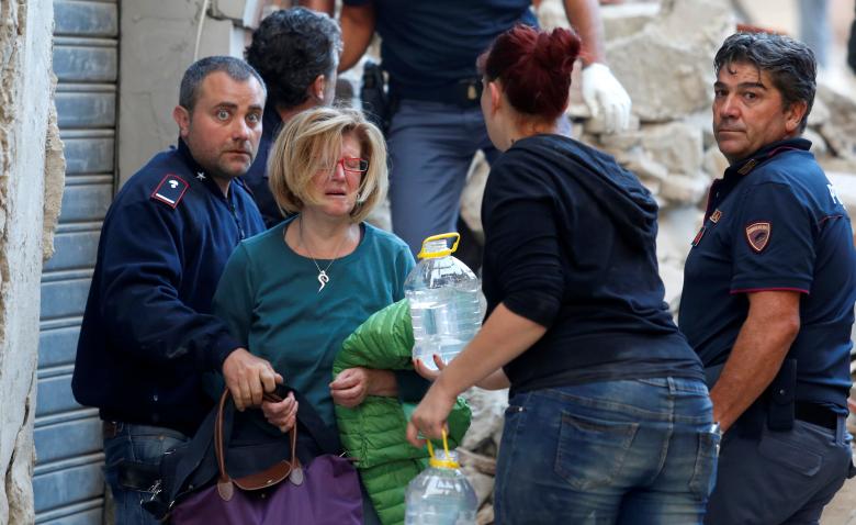 A woman (2nd L) cries after been rescued from her home following a quake in Amatrice, central Italy, August 24, 2016. REUTERS/Remo Casilli