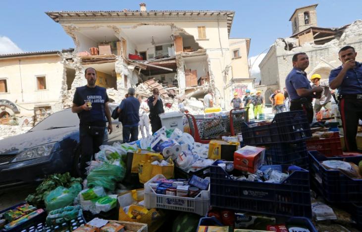 Rescuers prepare food and basic necessities in front of a partially collapsed building following an earthquake in Amatrice, central Italy, August 24, 2016. REUTERS/Ciro De Luca