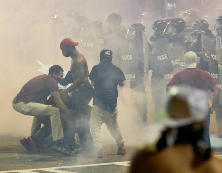 People maneuver amongst tear gas in uptown Charlotte, NC during a protest of the police shooting of Keith Scott, in Charlotte, North Carolina, U.S. September 21, 2016. REUTERS/Jason Miczek