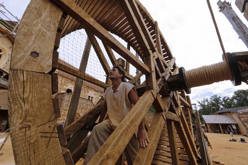 A worker walks in a winch drum at the construction site of the Chateau de Guedelon. REUTERS/Jacky Naegelen