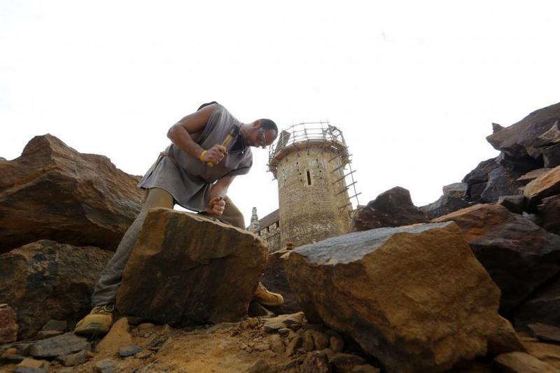 A stonecutter works at the construction site of the Chateau de Guedelon. REUTERS/Jacky Naegelen