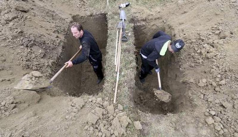 Grave diggers compete during the Grave Digging Championships in Trencin, Slovakia, Thursday, Nov. 10, 2016. (AP Photo/Ronald Zak)