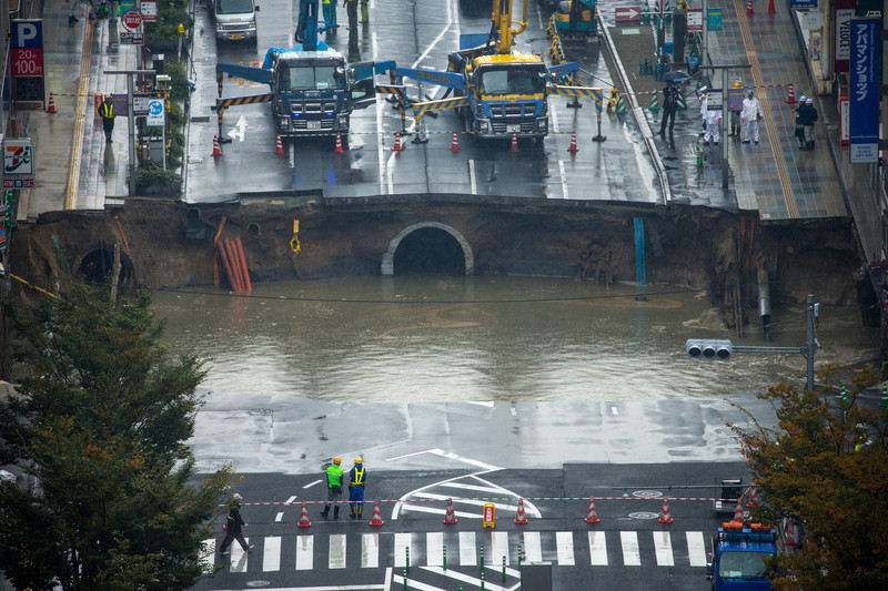 epa05621790 A large sinkhole cuts off an avenue in central Fukuoka, southwestern Japan, 08 November 2016. According to local media reports, the sinkhole has caused blackouts and disrupted traffic. Authorities have evacuated surrounding buildings in case of further damage. There were no immediate reports of damage or injuries.  EPA/HIROSHI YAMAMURA