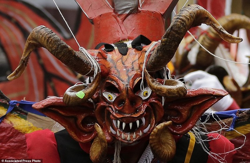 A devil dancer takes part in "La Diablada" festival in Pillaro, Ecuador, Friday, Jan. 6, 2017. Thousands of singing and dancing devils take over a mountain town in Ecuador for six days of revelry in the streets. (AP Photo/Dolores Ochoa)