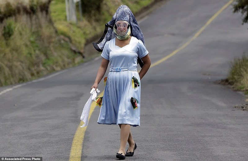 A woman dressed for la "La Diablada" festival, walks down a road in Pillaro, Ecuador, Friday, Jan. 6, 2017. Local legend holds that anyone who adopts a costume for the celebration and wears it at the event six years in a row will have good luck. (AP Photo/Dolores Ochoa)