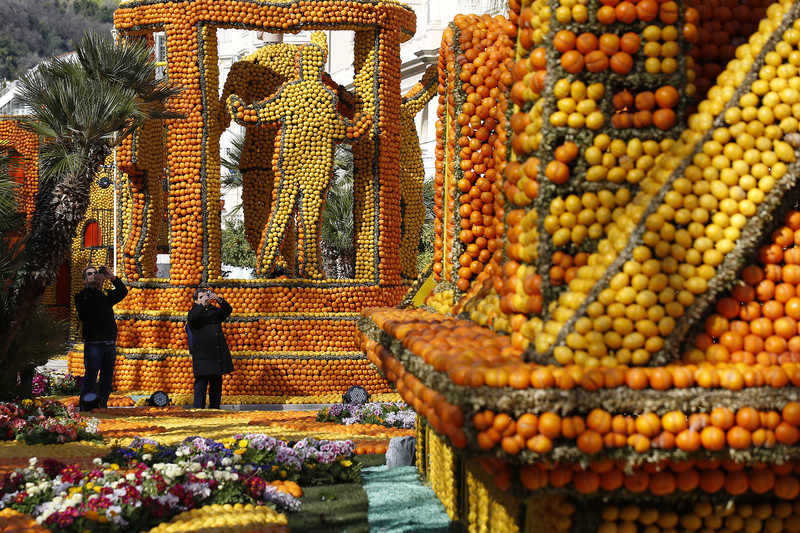 epa05795054 A woman take a pictures sculptures made with lemons and oranges at the 84th Lemon Festival in Menton, France, 15 February 2017. The 'Broadway' themed festival runs from 11 February to 01 March.  EPA/SEBASTIEN NOGIER