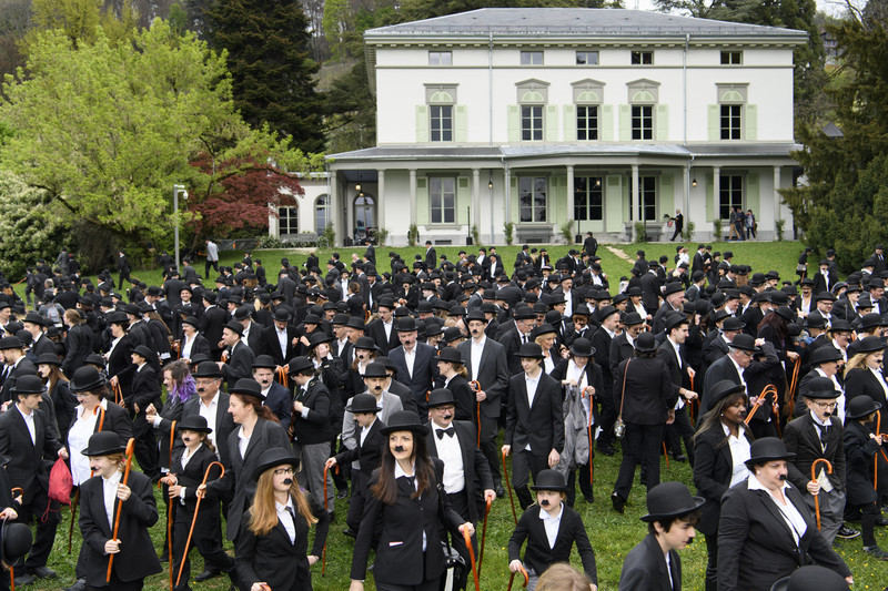 epa05910606 Over 662 people dressed as Charlie Chaplin pose for a group photo in front of the Manoir de Ban during an attempt of the world's largest gathering of people dressed as 'The Tramp' on the occasion of Charlie Chaplin's birthday, and to celebrate the first year of the museum "Chaplin's World by Grevin", in Corsier, above Vevey, Switzerland, 16 April 2017. Chaplin's World, a museum on English comic actor, filmmaker, and composer Charlie Chaplin, is located in a 14 hectare park of lush trees, it occupies the mansion where the Chaplin family lived the last 25 years of Charly Chaplin's life. EPA/LAURENT GILLIERON