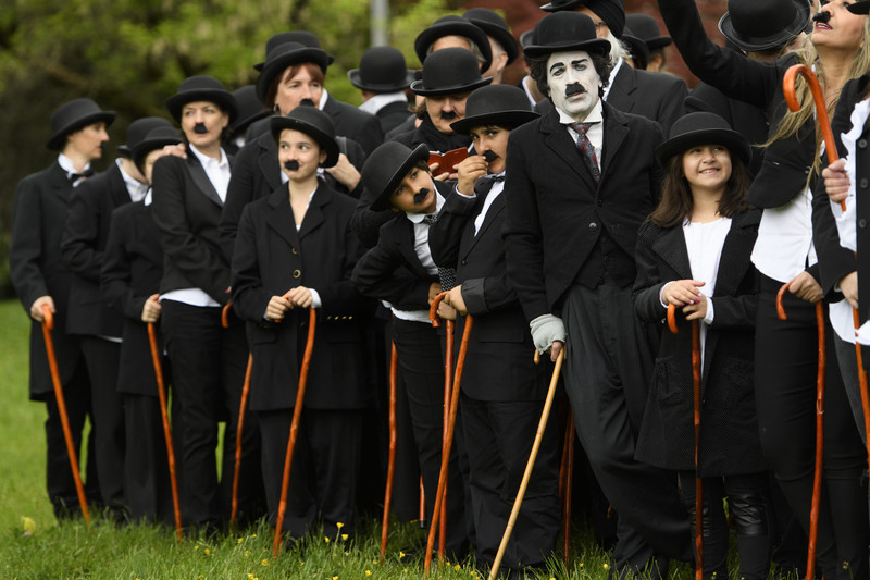 epa05910600 Over 662 people dressed as Charlie Chaplin pose for a group photo in front of the Manoir de Ban during an attempt of the world's largest gathering of people dressed as 'The Tramp' on the occasion of Charlie Chaplin's birthday, and to celebrate the first year of the museum "Chaplin's World by Grevin", in Corsier, above Vevey, Switzerland, 16 April 2017. Chaplin's World, a museum on English comic actor, filmmaker, and composer Charlie Chaplin, is located in a 14 hectare park of lush trees, it occupies the mansion where the Chaplin family lived the last 25 years of Charly Chaplin's life. EPA/LAURENT GILLIERON