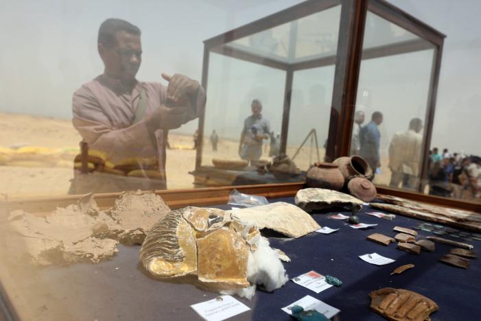 A man takes a photograph of objects that were found inside a burial site in Minya, Egypt May 13, 2017. REUTERS/Mohamed Abd El Ghany
