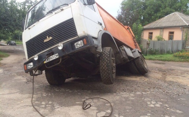 Мусоровоз застрял в дорожной яме посреди Харькова
