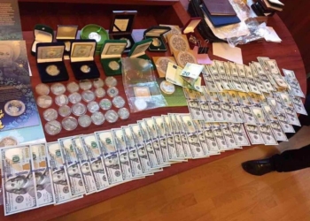 В доме начальника Шосткинского отдела полиции нашли флаг РФ и оружие, а в рабочем кабинете – $21,5 тыс., золотые слитки и коллекцию монет