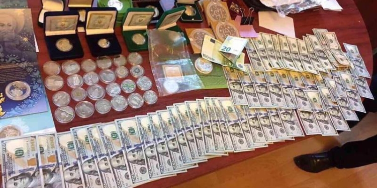 В доме начальника Шосткинского отдела полиции нашли флаг РФ и оружие, а в рабочем кабинете – $21,5 тыс., золотые слитки и коллекцию монет