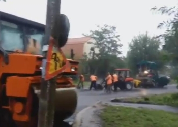 А красиво асфальтоукладчик бороздит лужи… В Николаеве даже в дождь укладывают асфальт