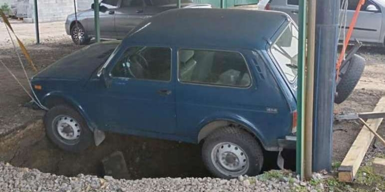 У Миколаєві на автостоянці автівка ледь не впала в 5-метрове провалля, яке утворилось через зруйновану каналізаційну трубу (ФОТО)