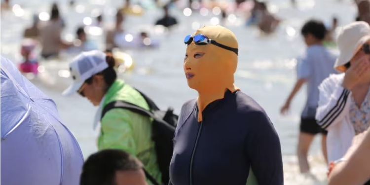 В Пекіні в шалену спеку китаянки рятуються “фейскіні” – масками на все обличчя